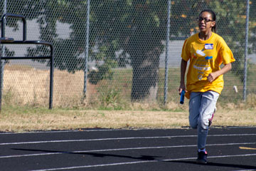 Student running with baton on track