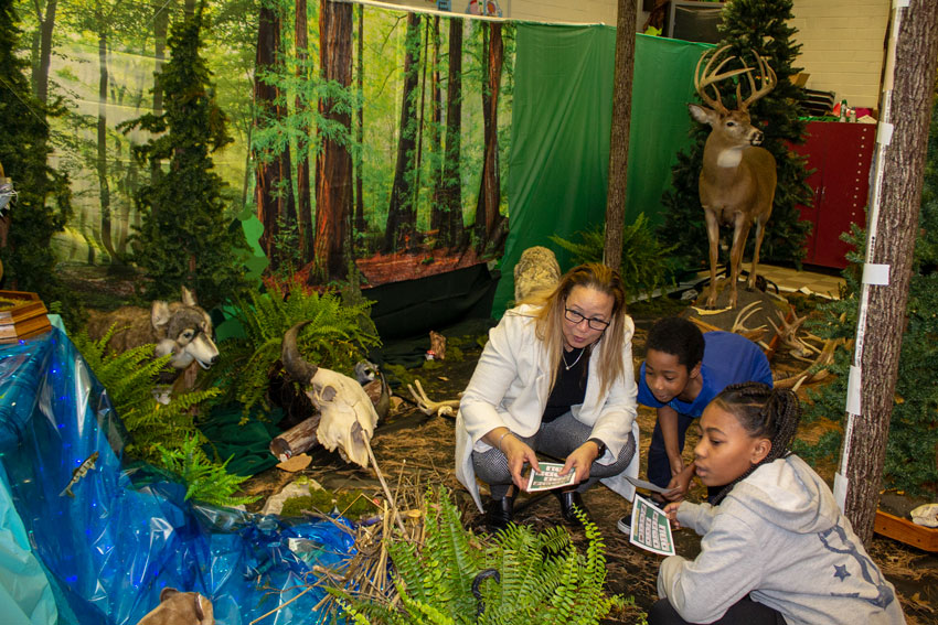 Teacher and students in classroom with woodland decorations