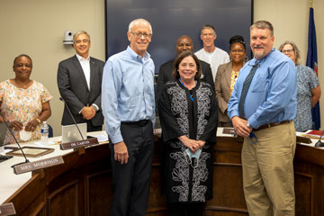 Three retiring School Board members surrounded by the other members