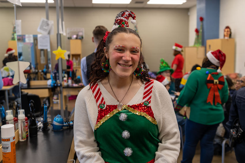 Student wearing holiday outfit in cosmetology classroom 