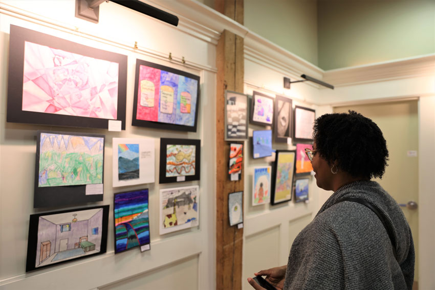 Woman looking at student art on display