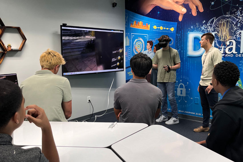 Student using VR headset while others watch