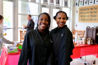 Two culinary arts students smiling at refreshment table