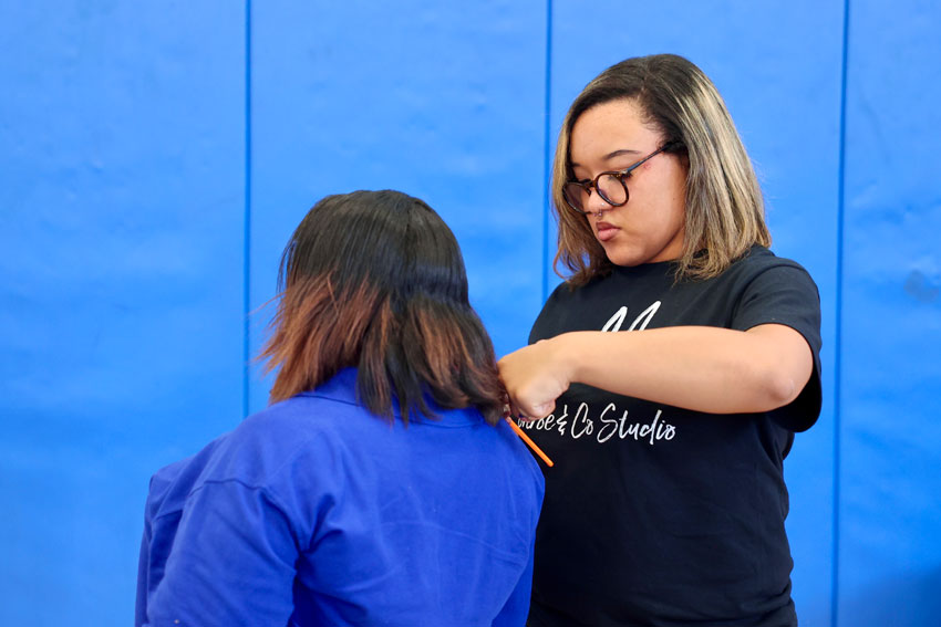 Hairstylist cutting student's hair