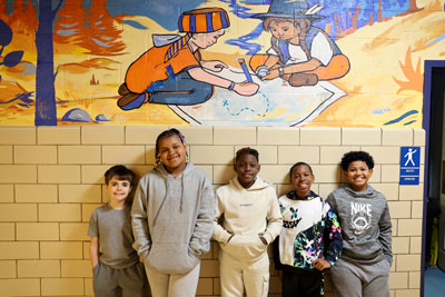 Students standing front of school mural