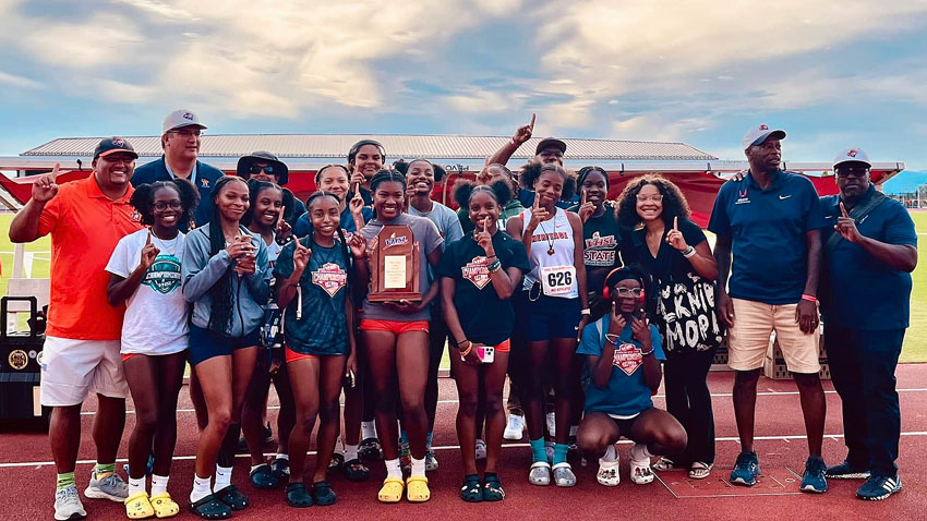 Girls track team holding state championship trophy
