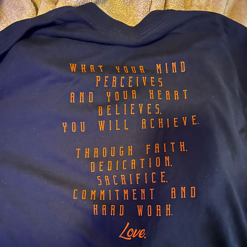Shirt with quote "What your mind perceives and your heart believes, you will achieve. Through faith, dedication, sacrifice, commitment and hard work. Love."