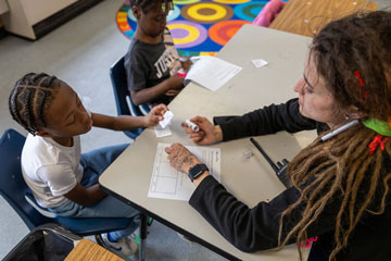 Behavior coach at table working with students