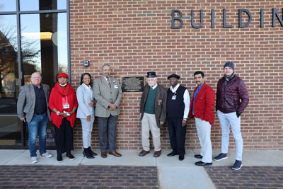 Superintendent, School Board and Dr. Potter in front of commemorative plaque