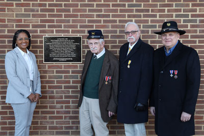 Superintendent in front of plaque with 3 members of Sons of Union Veterans Of The Civil War