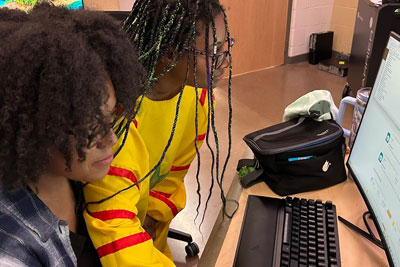 Two students working on computer
