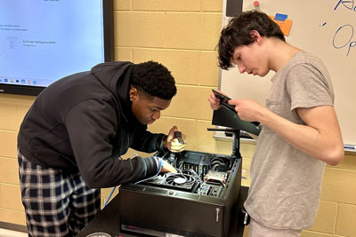 Two students working on computer hardware