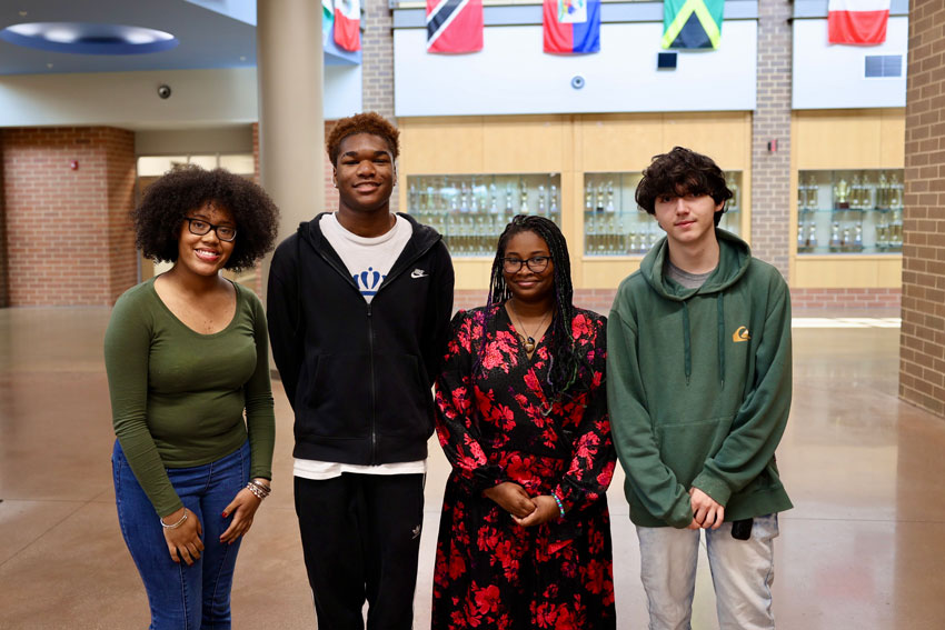 Four students posing in school hallway