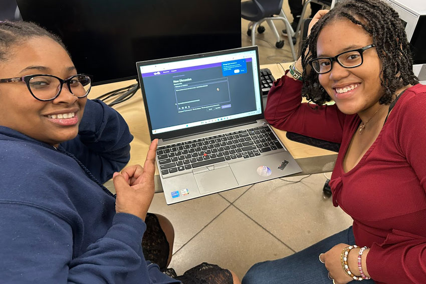 Two students in front of laptop