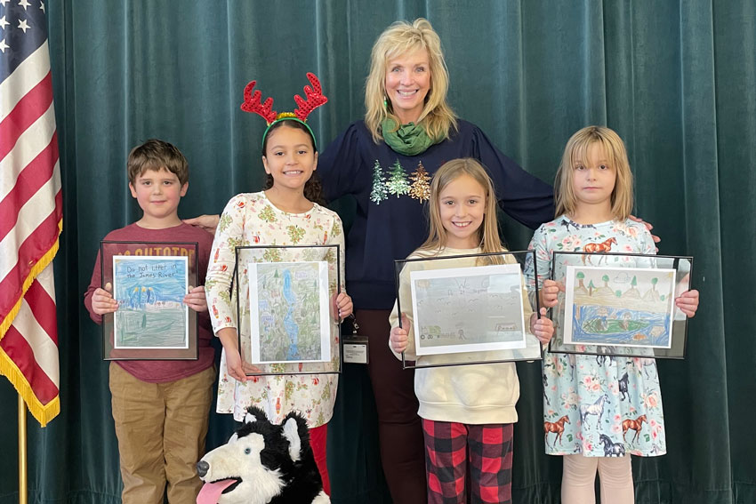 Teacher and four students holding award winning artwork