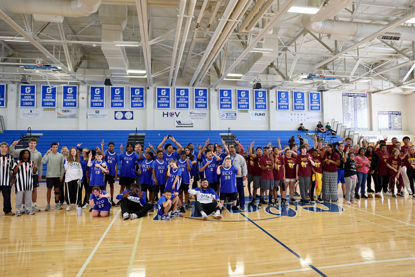 Group photo of two basketball teams on the court