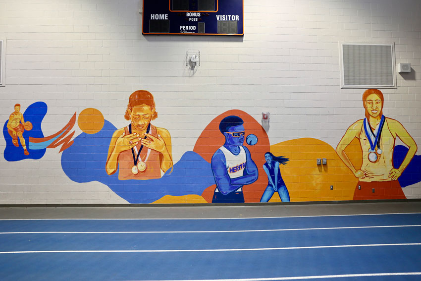 Mural of various athletes in high school gym