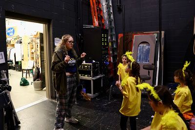 High school student backstage with theatre camp participants