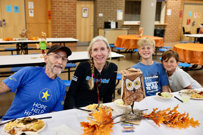Family in school cafeteria eating meal