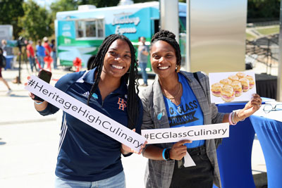 School staff holding signs that read #HeritageHighCulinary and #ECGlassCulinary