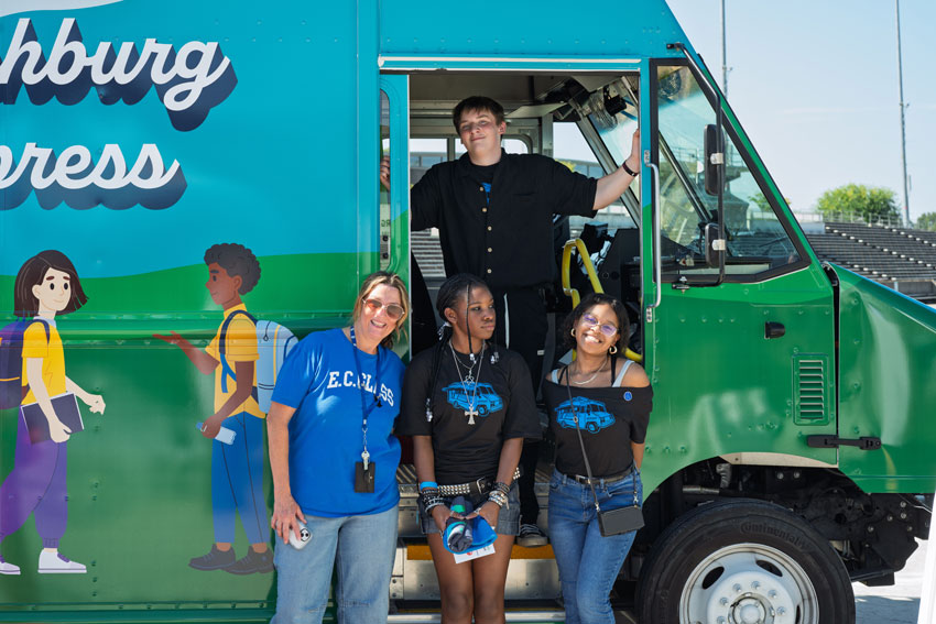 Students and teacher standing in door of food truck