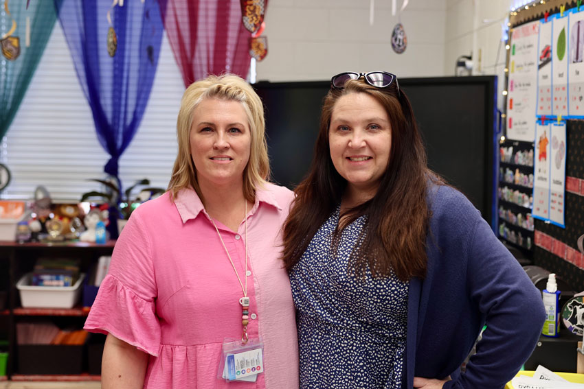 Two teachers standing a classroom