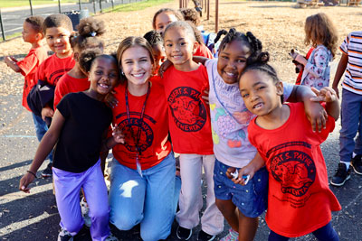 Smiling teacher and students on playground in matching R. S. Payne shirts