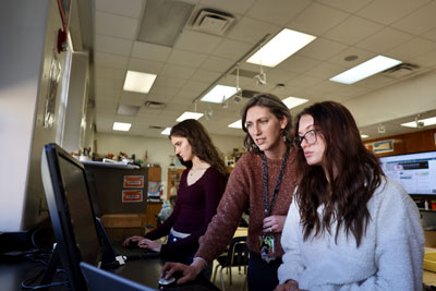 Teacher working with student on computer layout