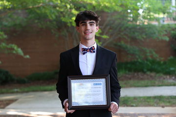 Scholarship recipient Enzo Wagner Zechin holding certificate