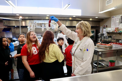 CVCC faculty holding shellfish up to show group of elementary students