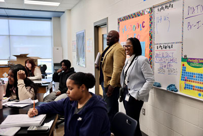 Superintendent and principal standing at the back of classroom