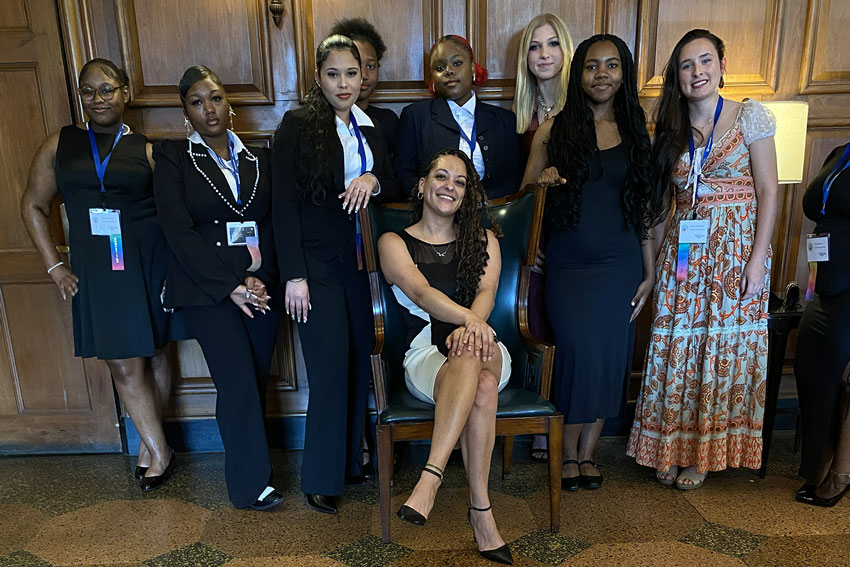 Group photo of students and teacher dressed in professional attire at leadership conference