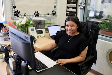 Attendance clerk Mia Reeves seated at her desk