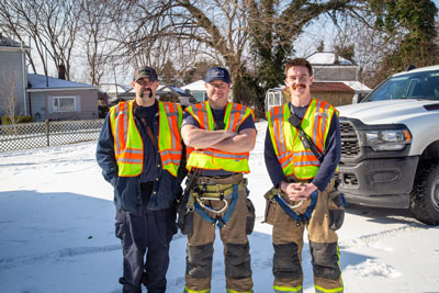 Three firefighters standing outside with snow on the ground