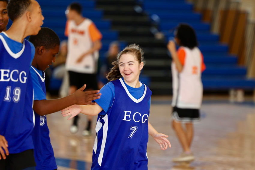 Smiling basketball player giving teammate 5