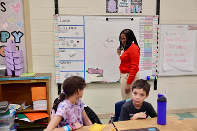 Superintendent at whiteboard with student looking on