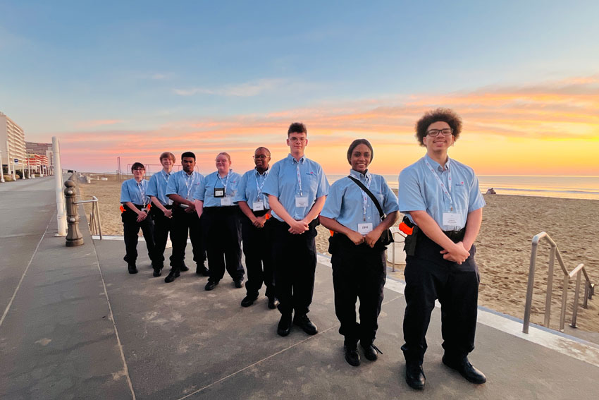 Eight students dressed in matching SkillsUSA uniforms on Boardwalk at Virginia Beach