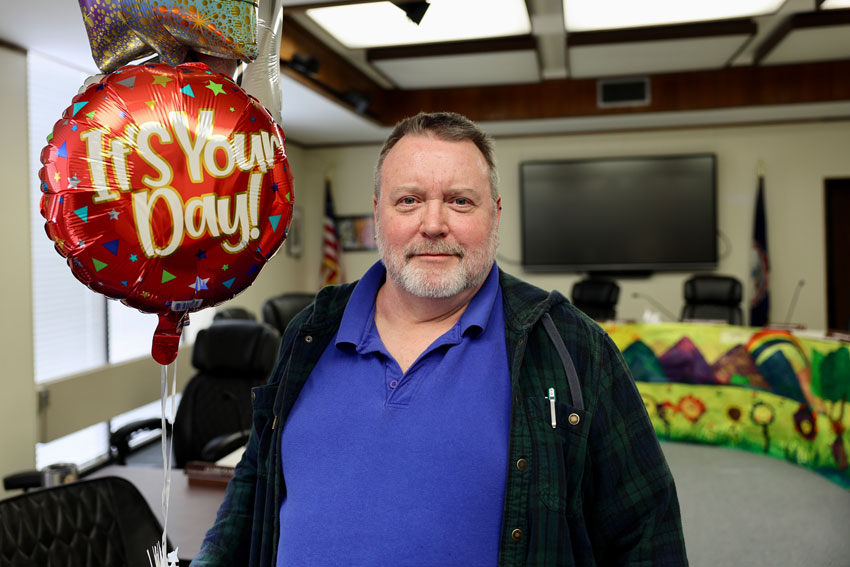 Staff member holding balloons in School Board room