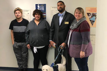 Two students, a teacher, a guest speaker and his therapy dog