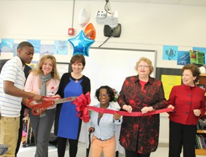 Partners cutting ribbon in classroom