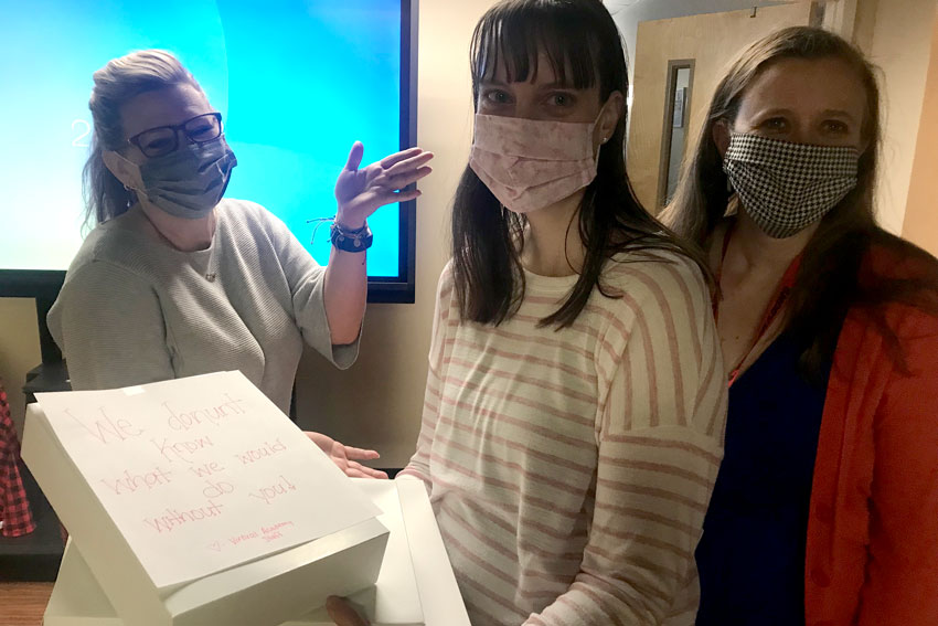 School Counselor holding box with note "We donut know what we would do without you! - Virtual Academy Staff"