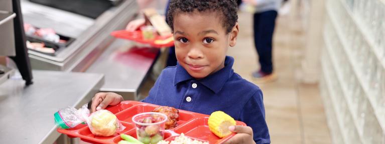 Student holding lunch tray in cafeteria