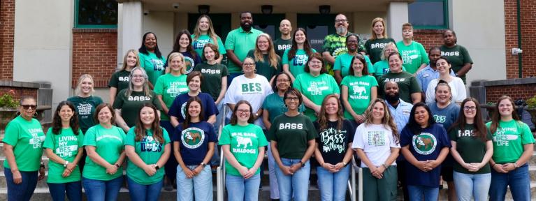 Bass staff standing on front steps of the school