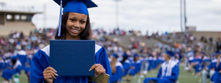 Student holding her diploma at graduation