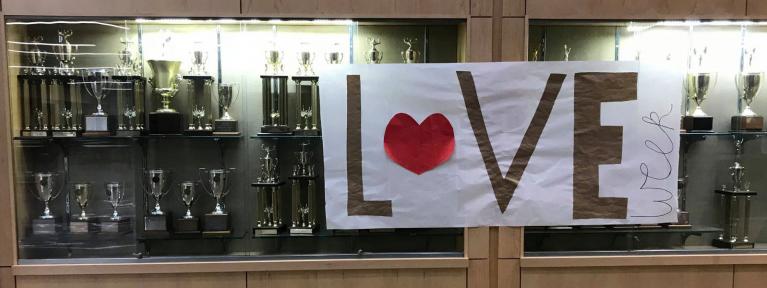 trophy case with love week banner
