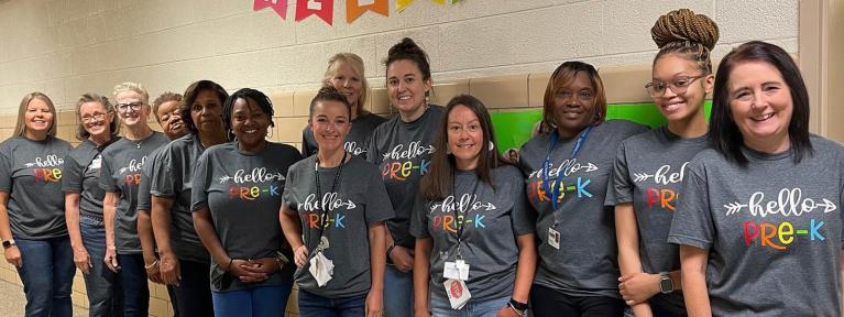 Group of teachers and staff in hallway wearing matching "Hello Pre-K" shirts