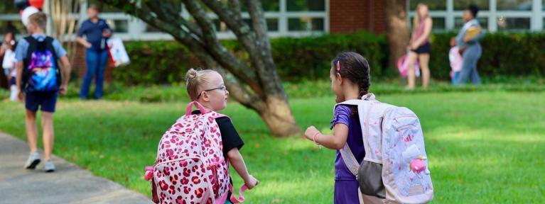 Two girls walking into school