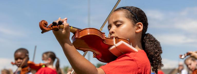 Girl playing violin outside