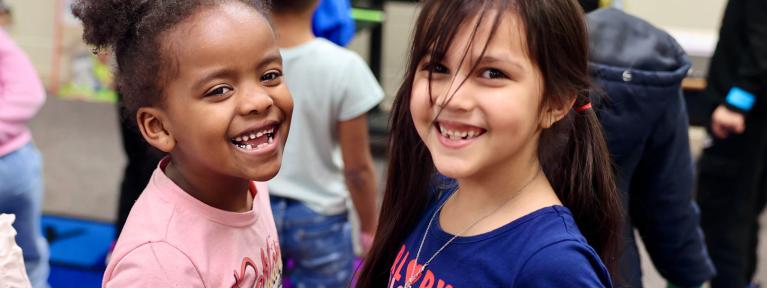 Two girls smiling in classroom