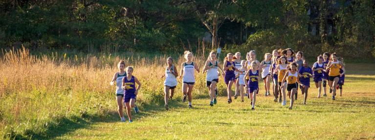 Girls cross country athletes running course